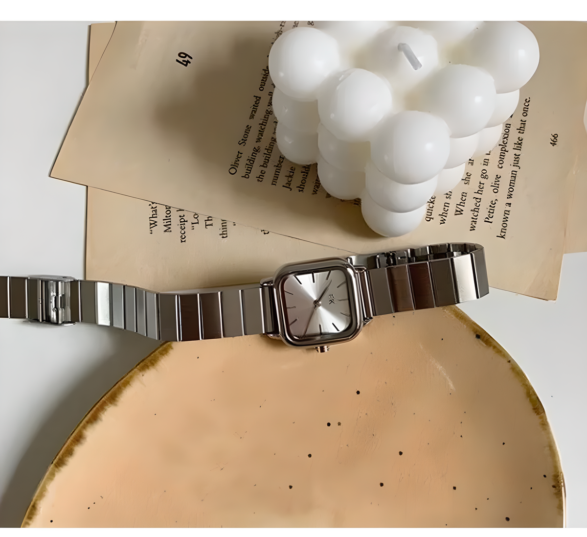 Silver watch on a white surface with text overlay